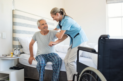 caregiver helping old man to stand